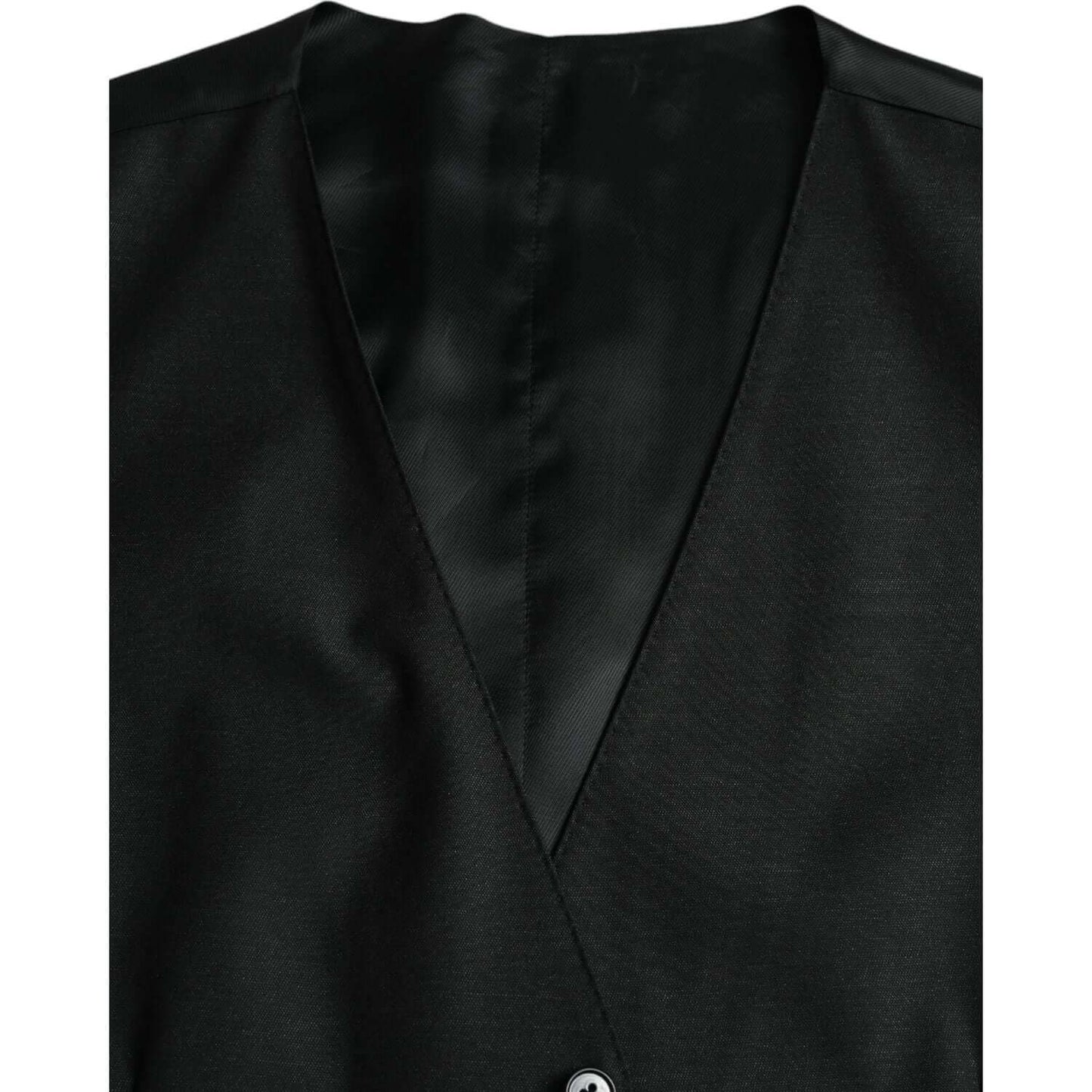 Dolce & Gabbana black wool waistcoat dress with adjustable strap and button closure, made of virgin wool and silk blend.