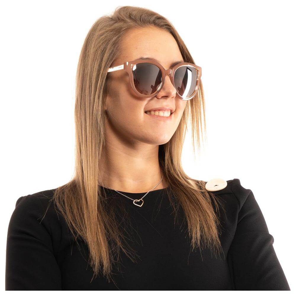 Woman wearing Guess brown butterfly sunglasses with mirrored silver lenses and full-rim metal and plastic frame.