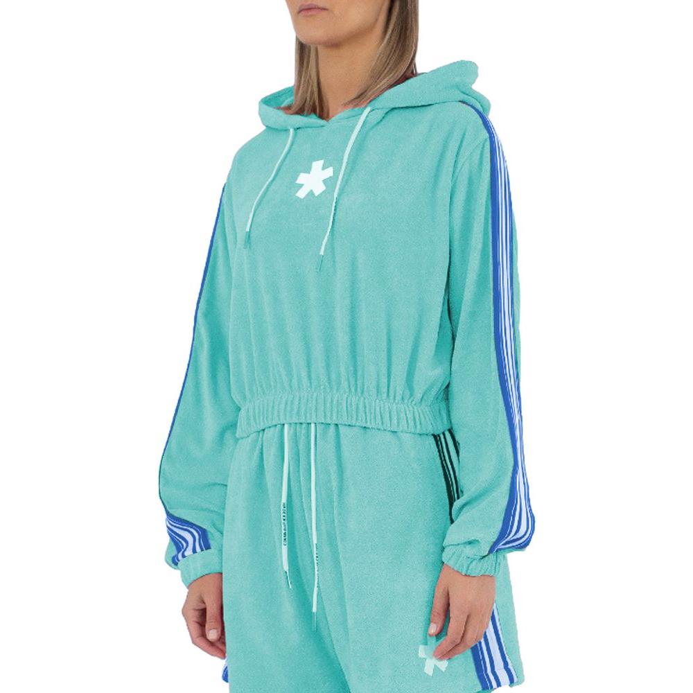 Woman wearing a Comme Des Fuckdown green cotton sweater with hood, drawstring, and logo print in a casual pose.