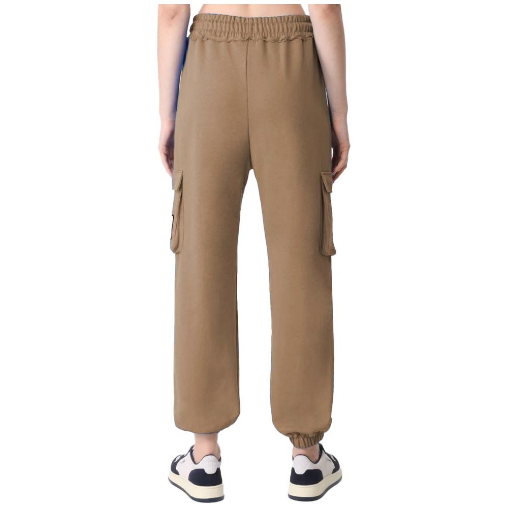 Rear view of Comme Des Fuckdown brown fleece pants with cargo pockets and an adjustable waistband, worn with sneakers.