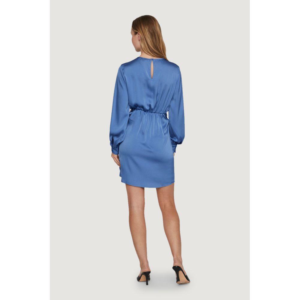 Woman wearing a Vila Clothes blue recycled polyester dress, spring/summer collection, showing back with long sleeves and short hem.