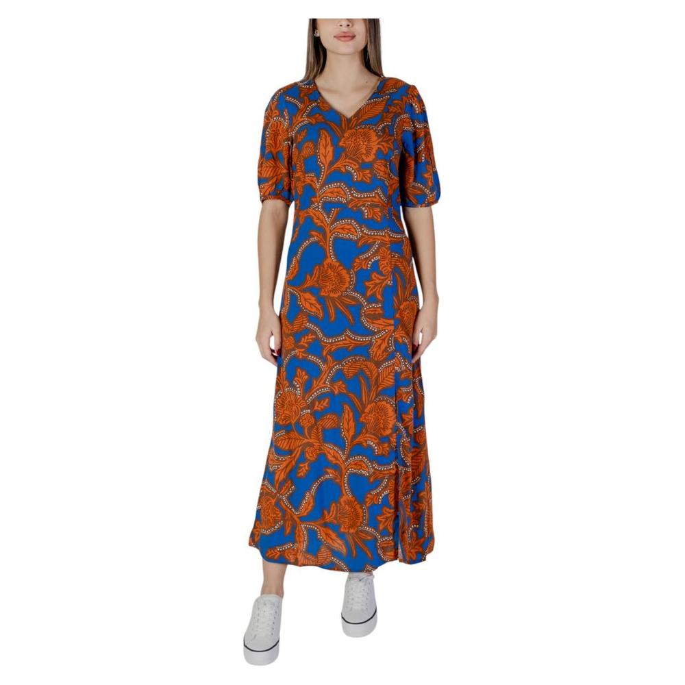 Woman wearing a B.Young blue viscose dress with orange floral patterns, spring/summer collection.