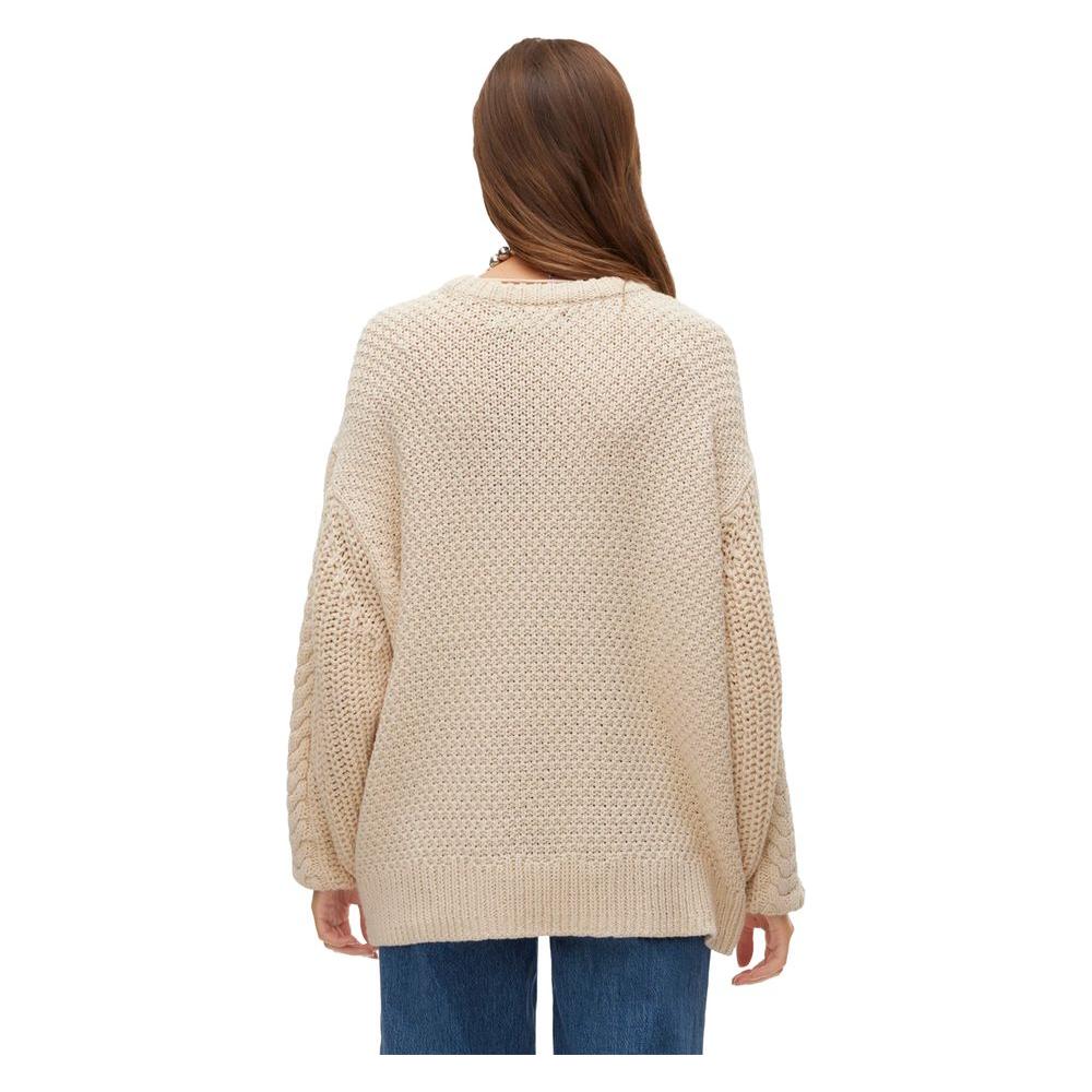 Alt Tag: Back view of a woman wearing a Vero Moda beige cotton sweater, part of the women's knitwear fall/winter collection, 60% cotton, 40% acrylic.