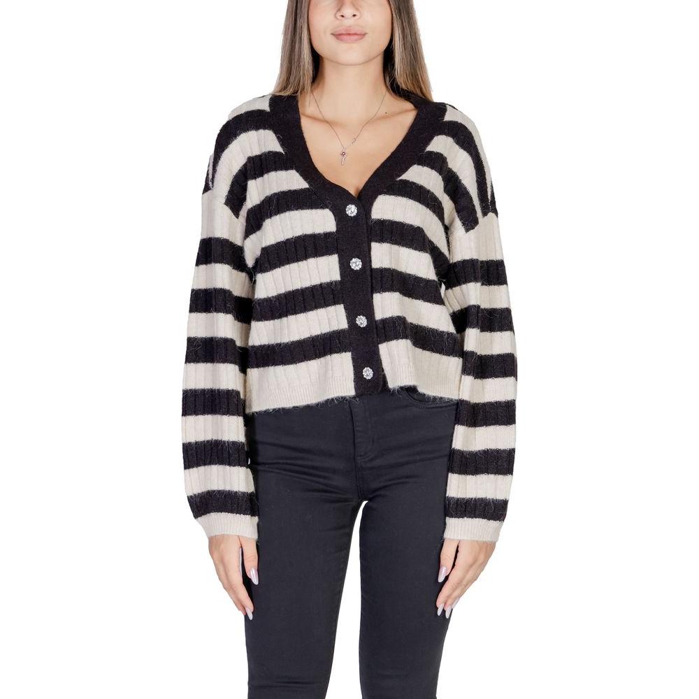 Woman wearing black and white striped cardigan with buttons, paired with black pants, showcasing stylish women's knitwear fashion.