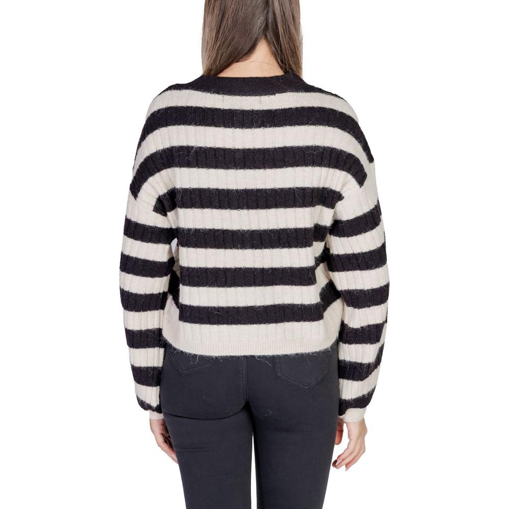 Back view of woman wearing a black and white striped knit sweater with long sleeves.