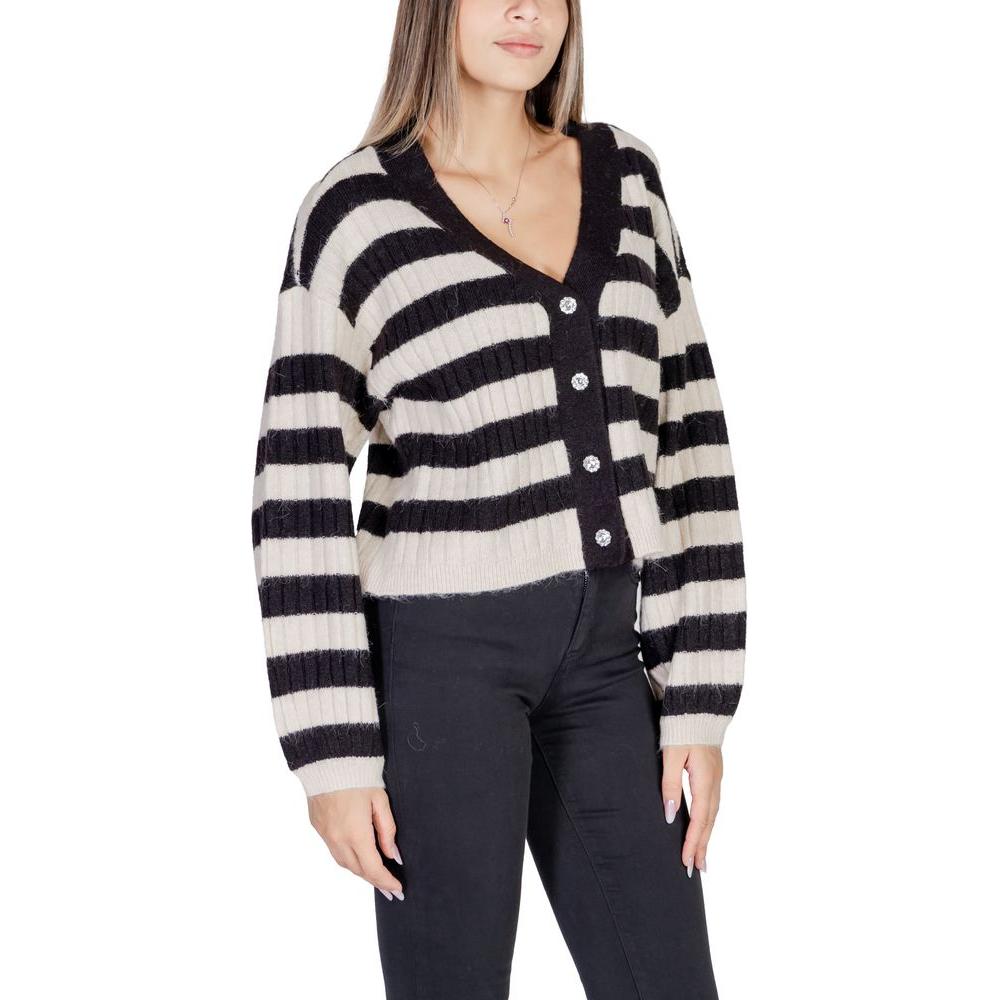 Woman wearing a Vero Moda beige polyester cardigan with black and white stripes, part of the Fall/Winter women's knitwear collection.