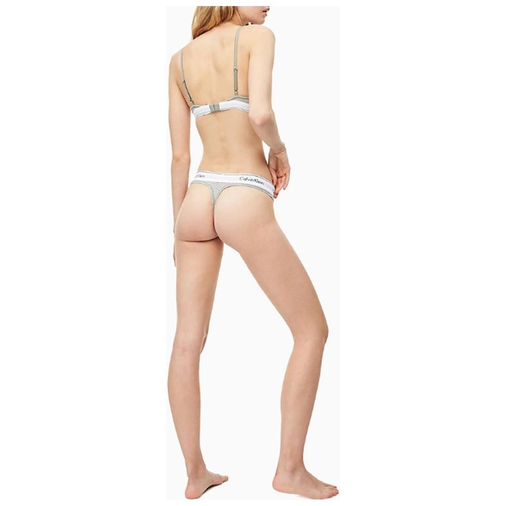Back view of a model wearing Calvin Klein gray cotton thong underwear, showcasing stylish minimalist design and comfortable fit.
