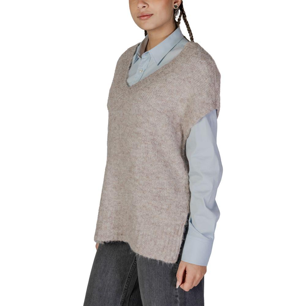 Woman wearing Vero Moda beige recycled polyester sweater over blue shirt, fall/winter collection