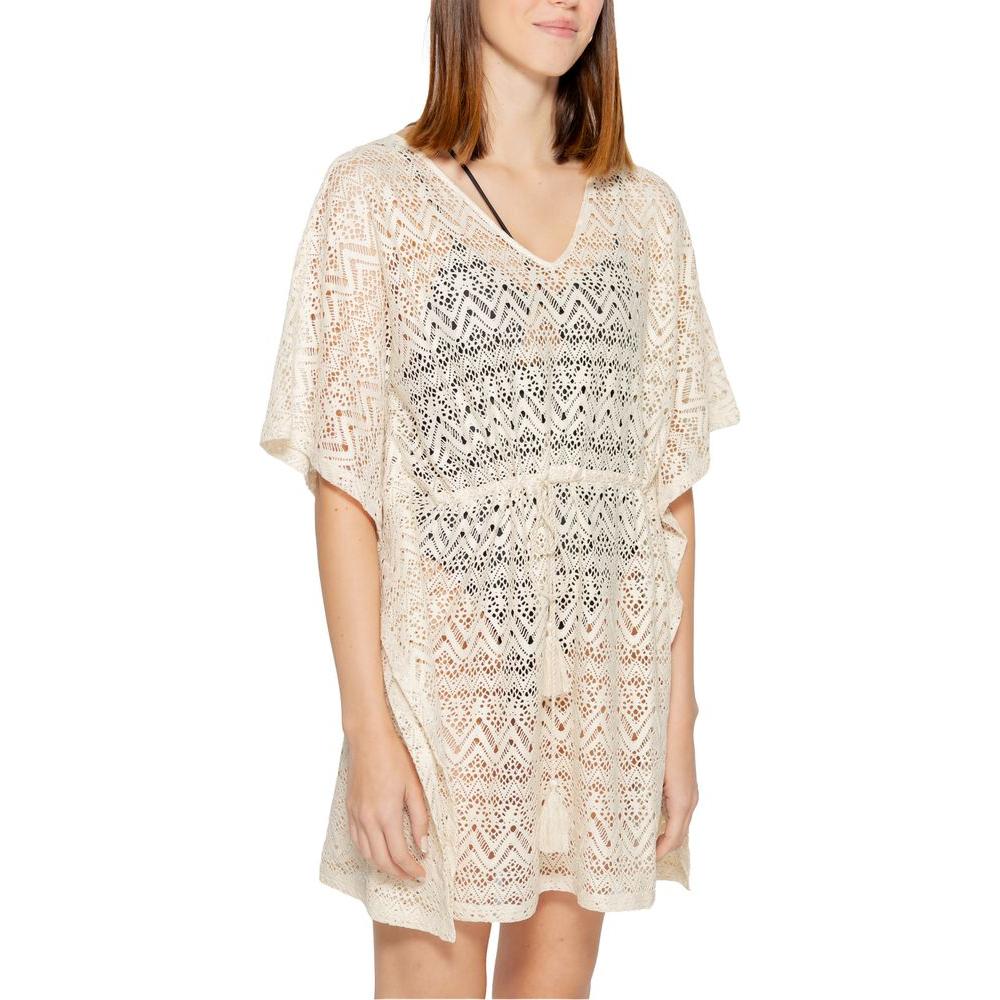 Woman wearing a Vero Moda beige polyester short dress, part of the Spring/Summer collection, with lace details and v-neck design.