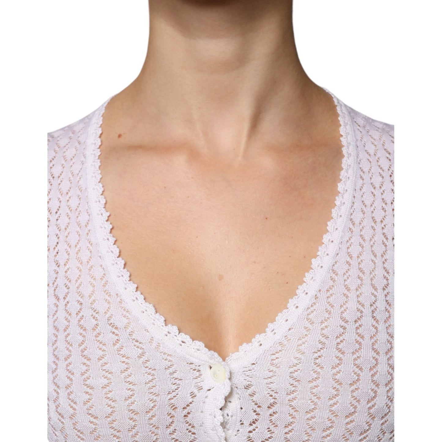 Close-up of a white Dolce & Gabbana silk button-down cardigan sweater showcasing intricate knit pattern and V-neck detail.