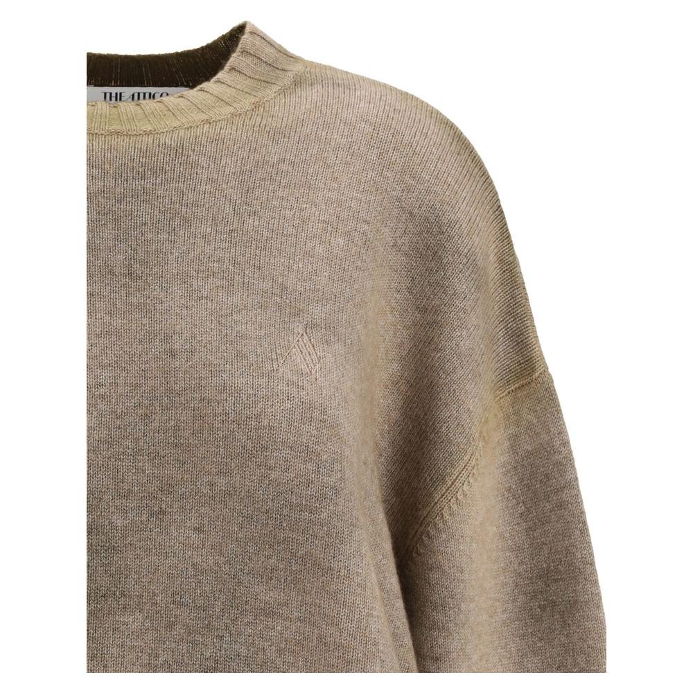 Close-up of The Attico wool sweater with ribbed crew neck, wide sleeves, and asymmetrical hem in a loose fit design.