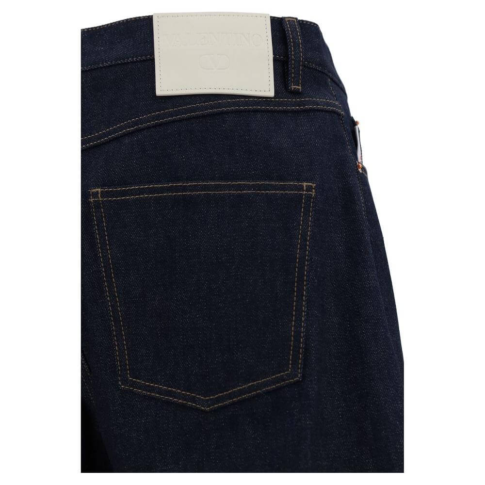 Back view of Valentino cotton jeans with iconic branded leather patch and five-pocket styling, featuring button closure and waistband loops.