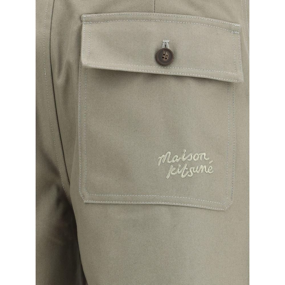 Back pocket of Maison Kitsuné workwear pants with embroidered brand monogram in monochrome cotton fabric.