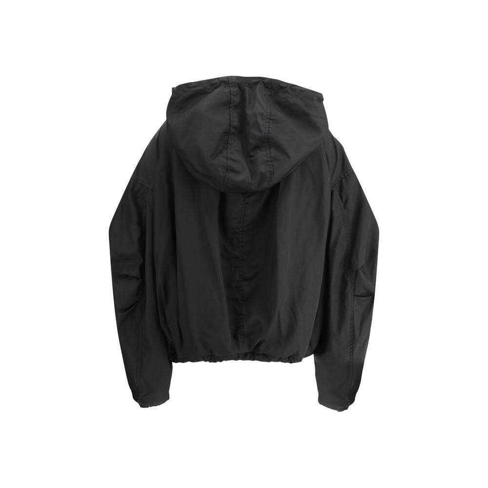 The Attico Nylon Windbreaker Jacket with adjustable hood and drawstring hem, offering elegance and protection against wind.