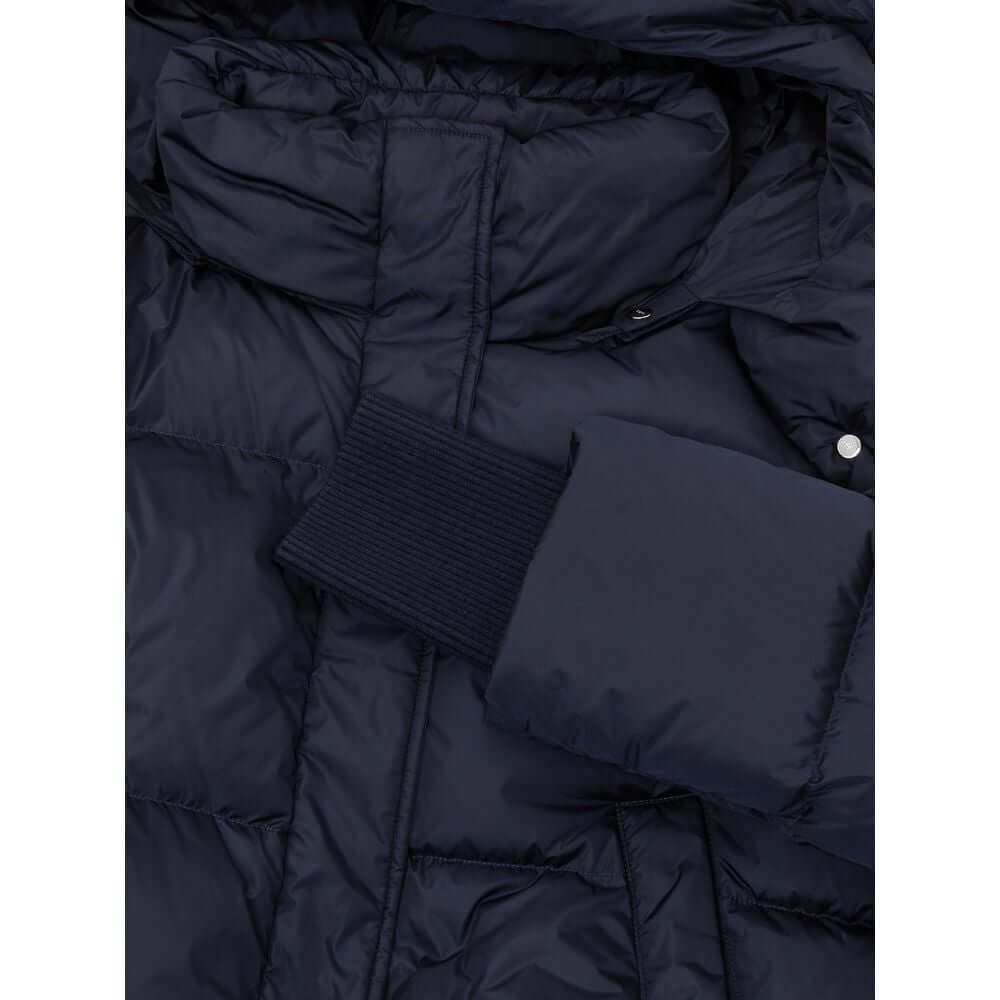 Close-up of a blue polyamide jacket with removable hood, knit cuffs, and zipper closure, showcasing its warm, lightweight fabric.