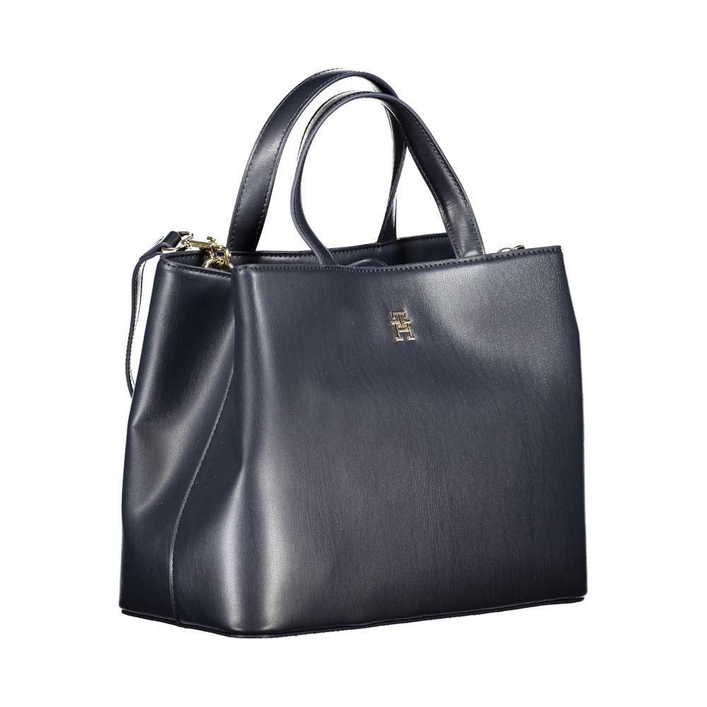 Tommy Hilfiger blue handbag with two handles, adjustable shoulder strap, logo, internal pocket, two compartments, and snap closure.