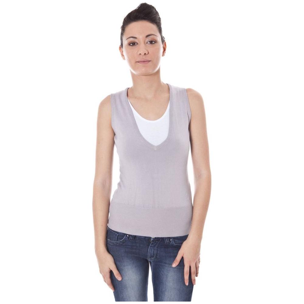 Woman wearing Datch gray cotton V-neck sweater vest with logo, paired with jeans, showcasing casual style.