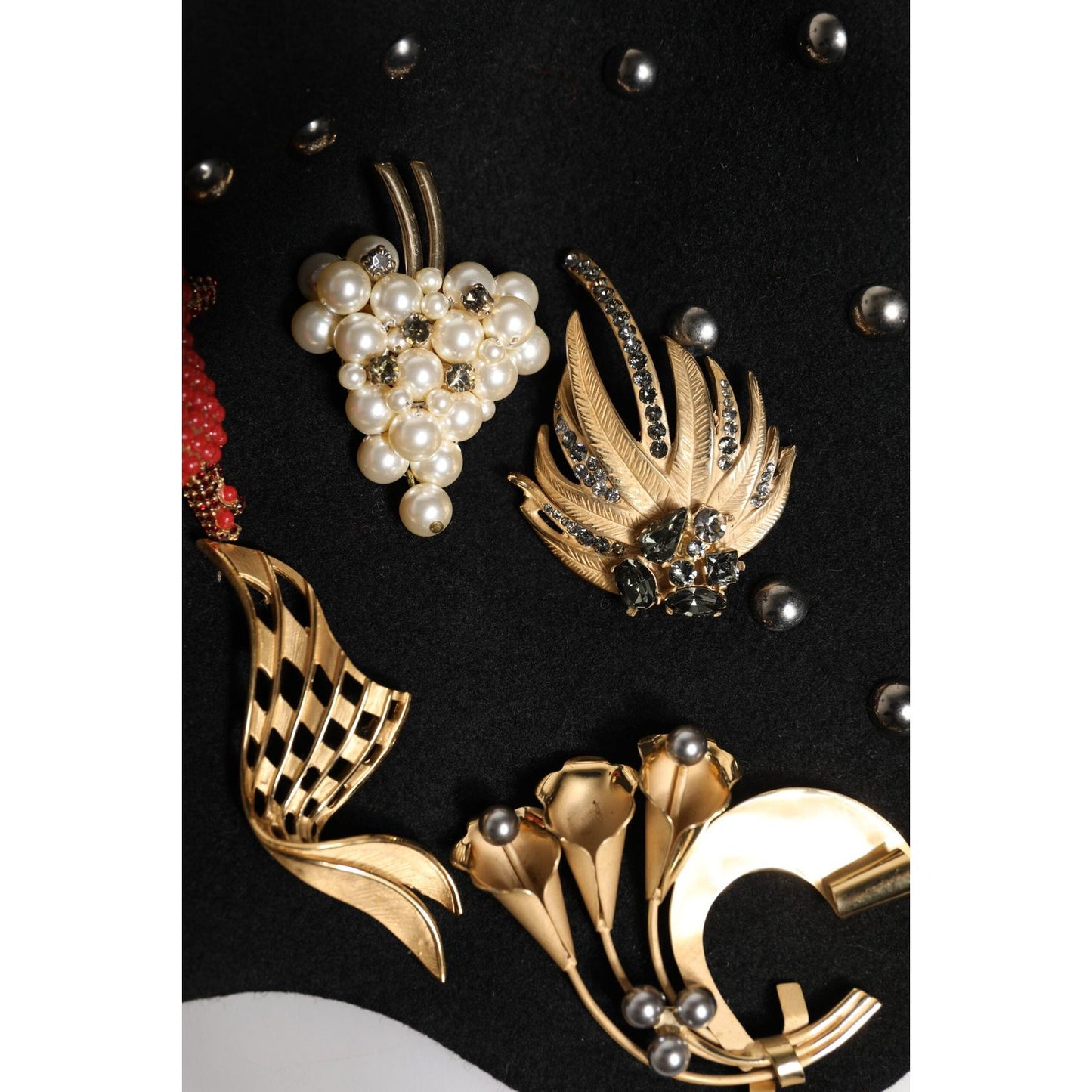 Detail of Dolce & Gabbana embellished cloche hat with crystal and pearl accents on black wool fabric.