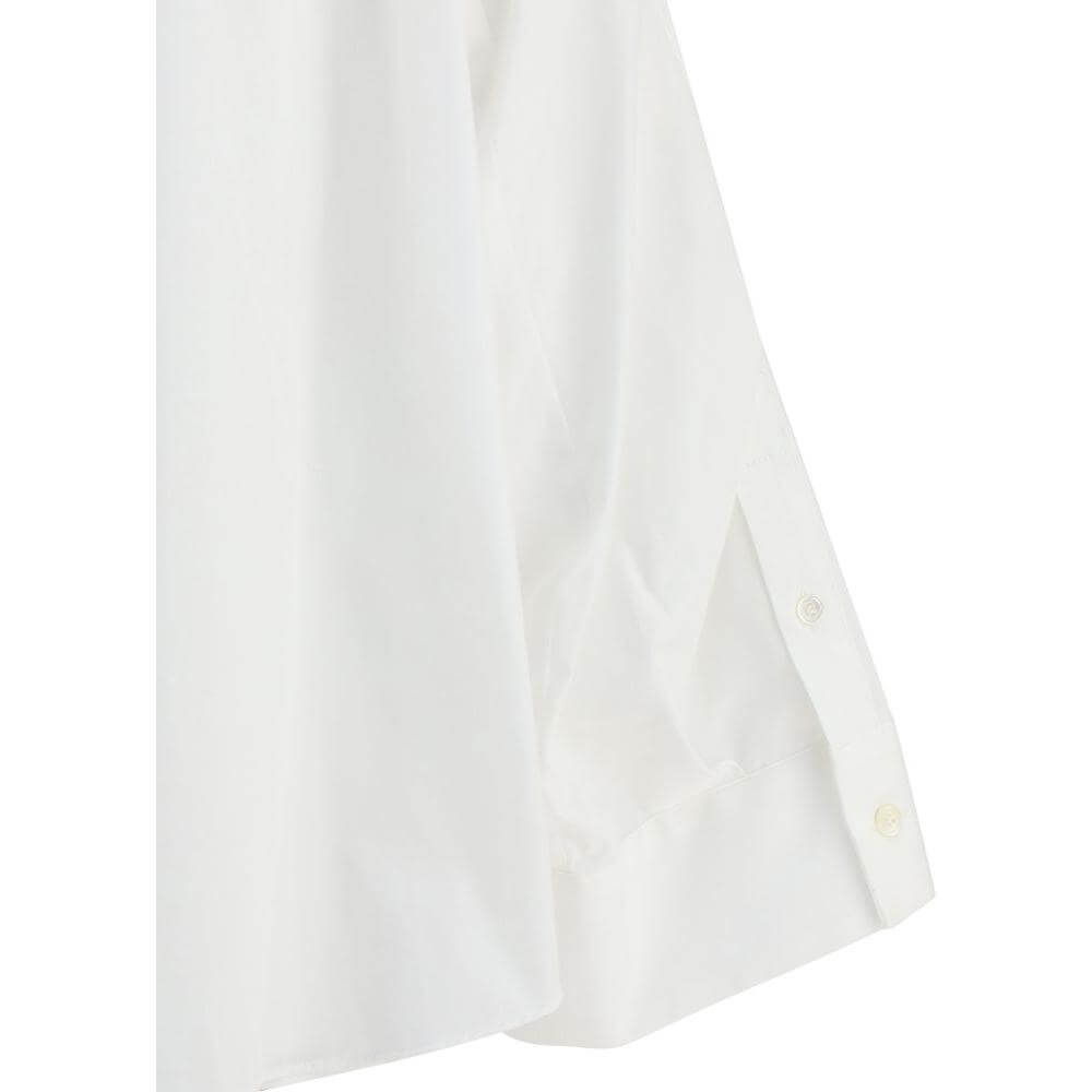 Close-up of Sacai three-quarter sleeve shirt with wide cuffs and button detail in white cotton.