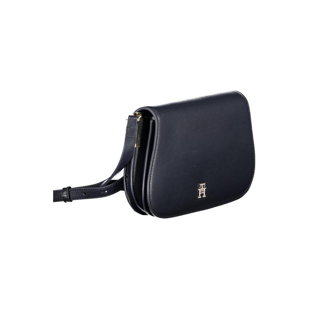 Tommy Hilfiger blue polyethylene handbag with adjustable shoulder strap, internal pocket, snap closure, and logo detail.