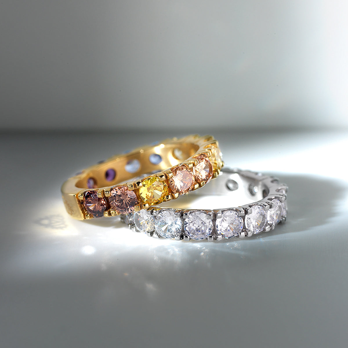 Two elegant rings with gemstones, featuring AN JEWELS JEWELRY Mod. AL.RLOY1YF-8, displayed on a reflective surface.