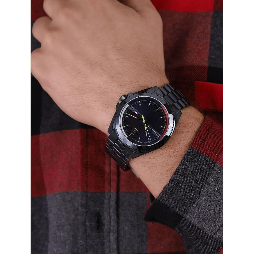 Gent wearing TOMMY HILFIGER Mod. 1791689 watch on wrist with black dial and bracelet, highlighting quartz analog movement and style.