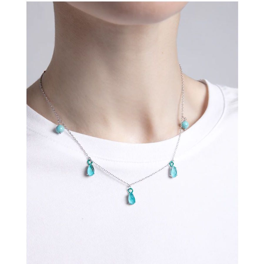 Lady wearing VICEROY JEWELS Mod. 13197C000-93 silver necklace with turquoise gemstones on a white shirt, delicate and elegant design.