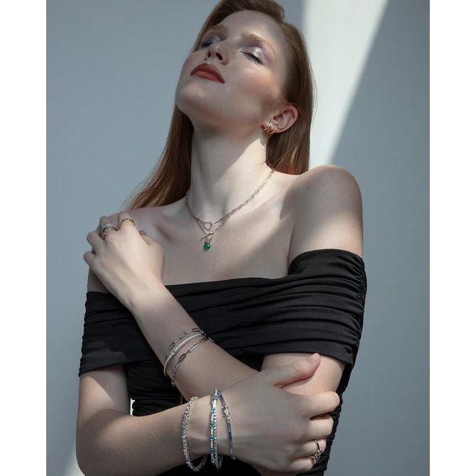 Lady wearing a black off-shoulder dress with VICEROY JEWELS Mod. 13230C000-30 necklace and silver accessories, mood lighting.