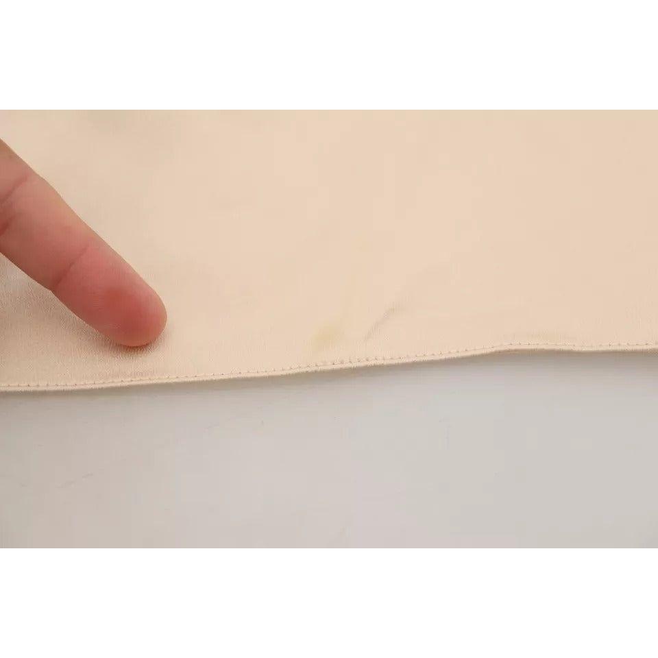 بلوزة من الدانتيل البيج مع شعار السباغيتي من دولتشي آند غابانا