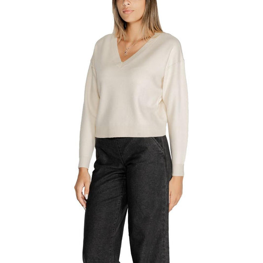 Woman wearing Vero Moda white viscose sweater from fall/winter collection, paired with black pants.
