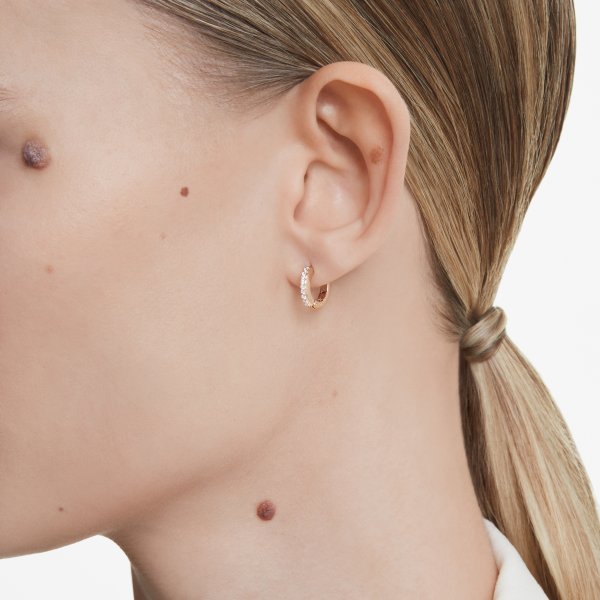 Woman wearing SWAROVSKI Mod. 5690669 earrings, silver 925°, 38mm case, quartz analog, 5 ATM water resistance, mineral dial.