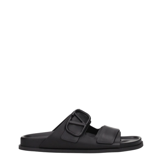 Valentino Garavani Black Leather Slippers with open toe and rubber sole, featuring a front logo design and low flat heel.