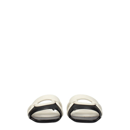 Valentino Garavani Black Leather Slippers with ivory trim, open toe, and low flat heel for casual style.