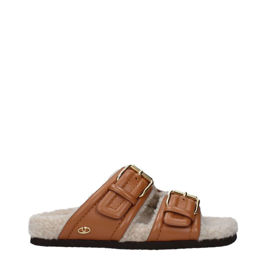 Valentino Garavani Brown Leather Slippers with buckle closure and rubber sole, featuring an open toe design and casual style.