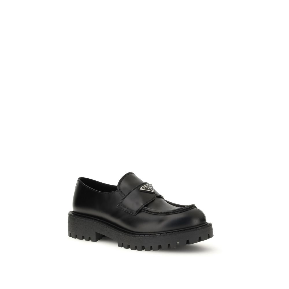 Prada Black Calf Leather Bos Taurus Slip-On Loafers with enameled triangle, rubber sole, and leather insole for AW25 season.