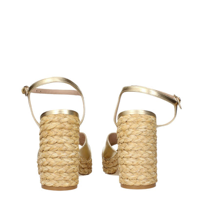 Stuart Weitzman Gold Leather Platform Sandals with metallic effect, showcasing woven heel design, view from the back.