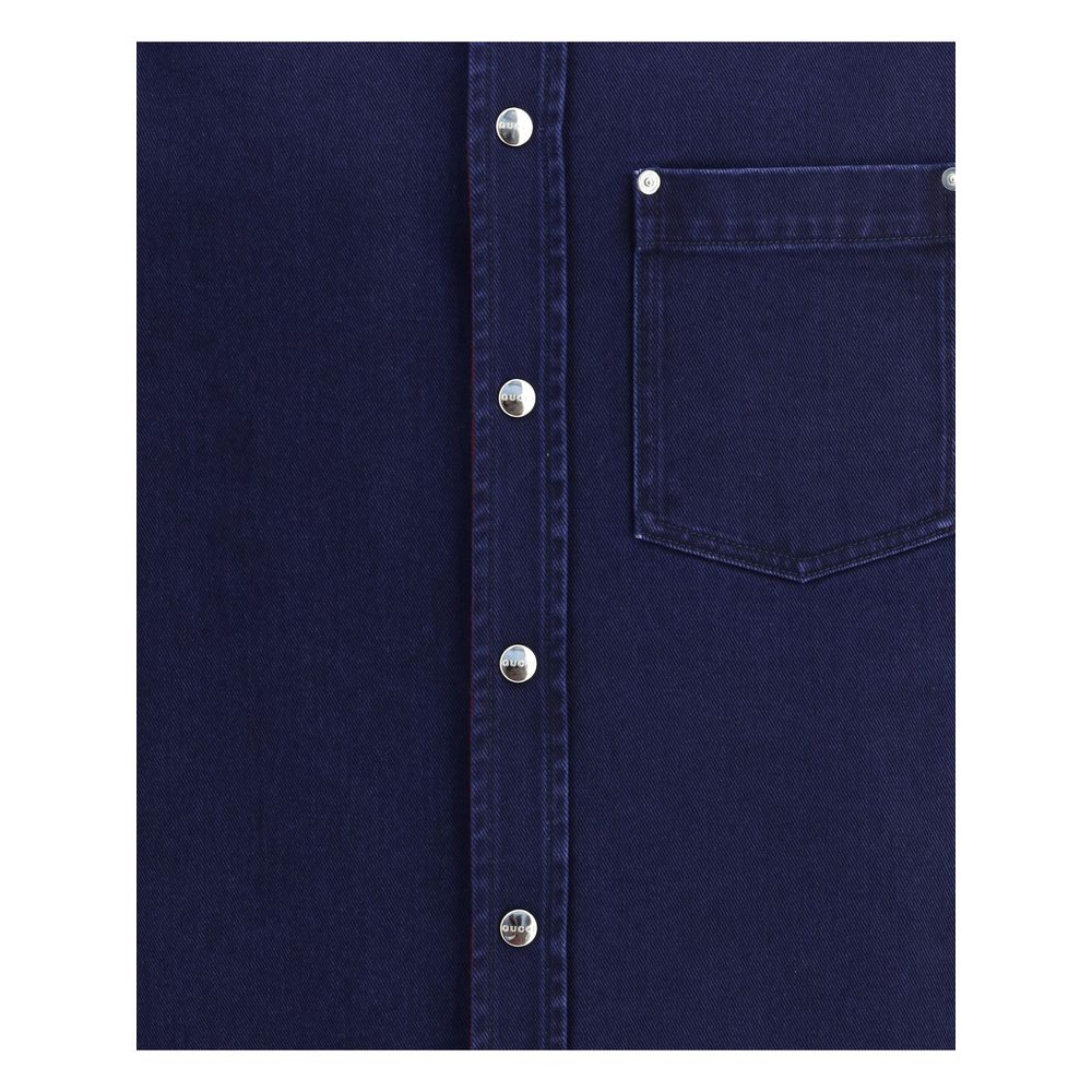 Close-up of Gucci Blue Denim Shirt featuring chest pocket and Gucci metal buttons, showcasing premium craftsmanship and style.