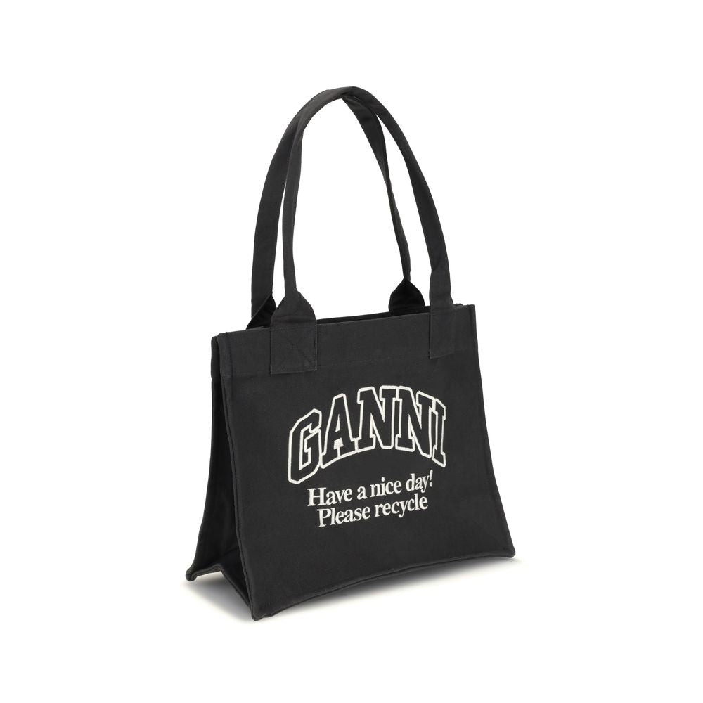Ganni Black Cotton Shoulder Bag with GANNI logo and sustainability message, featuring top handles and made from recycled cotton.