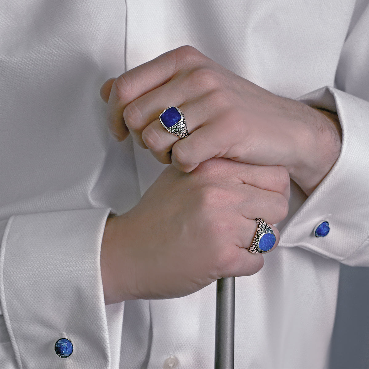 Close-up of ALBERT M. JEWELS JEWELRY Mod. WSOX00174.LPS featuring elegant rings and cufflinks with blue stones.