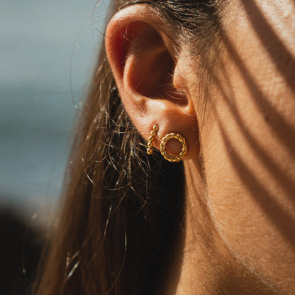 Close-up of a woman's ear wearing AN JEWELS JEWELRY Mod. AL.EMW02Y gold hoop earrings.