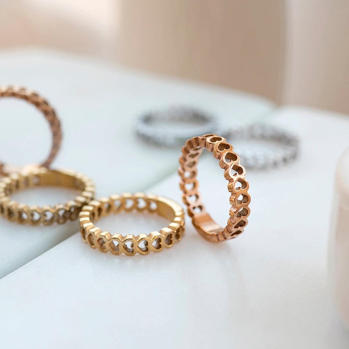 Elegant rings from AN JEWELS JEWELRY Mod. AL.RSC01SYR-9 displayed on a marble surface with gold and silver designs.