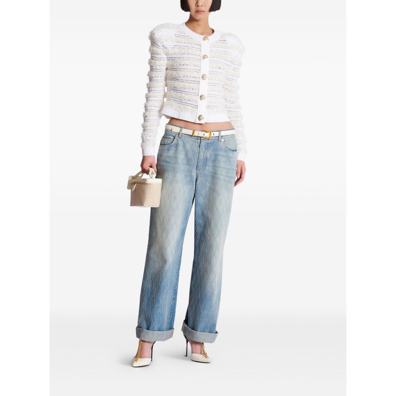 Model wearing Balmain Long-sleeved tweed-effect knit cardigan with jeans and holding a handbag.