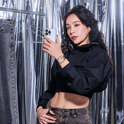 Woman wearing CASIO G-SHOCK Mod. MINI OAK G-STEEL wristwatch, posing with smartphone in metallic room.