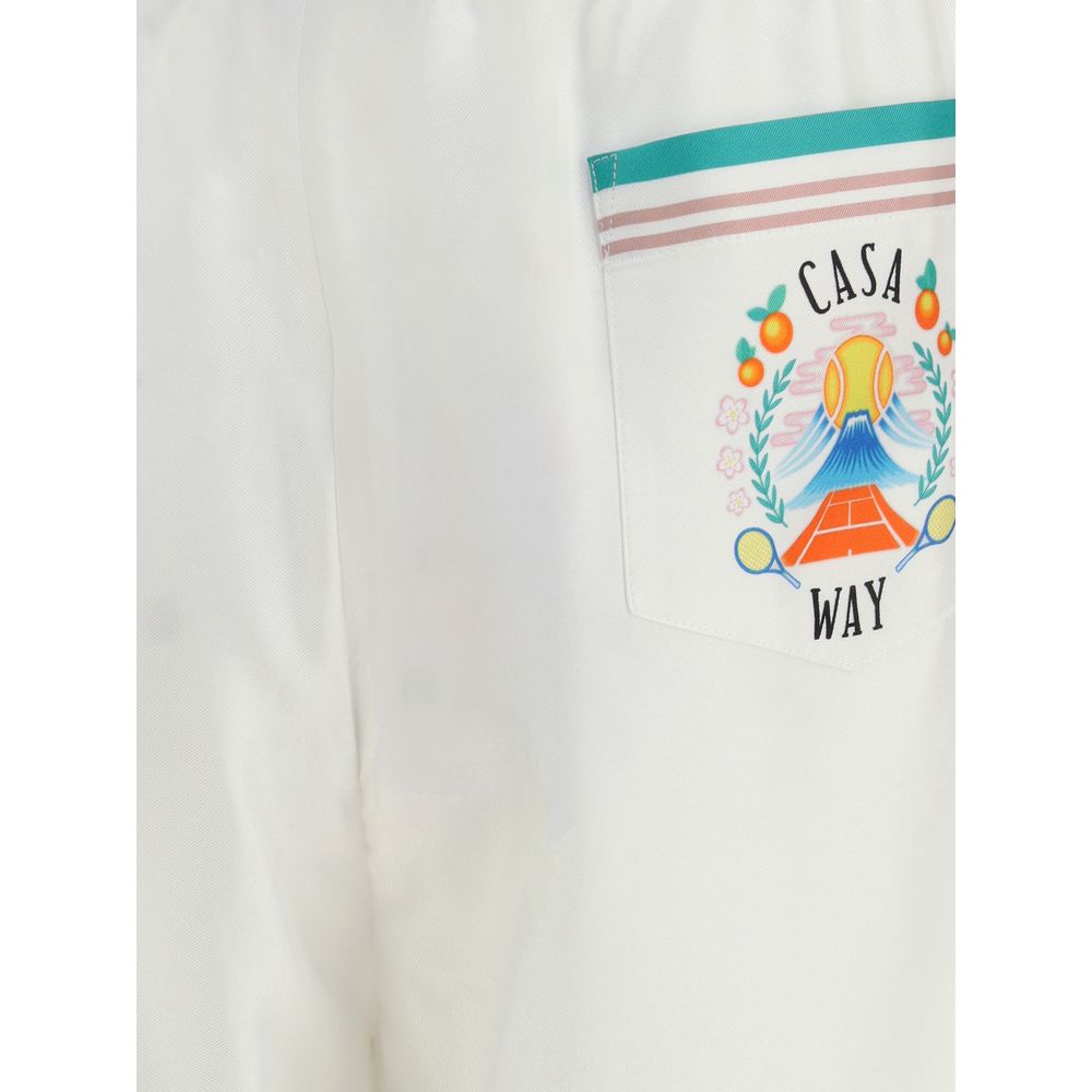 Close-up of Casablanca White Silk Bermuda Shorts with graphic design on back pocket, showcasing striped hem and Casa Way branding.