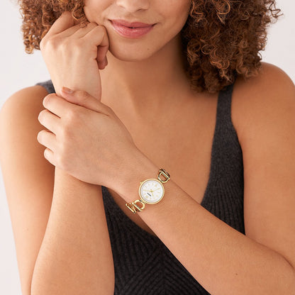 Woman wearing FOSSIL Mod. ES5272 quartz wristwatch with gold stainless steel case and strap, elegant design for ladies.