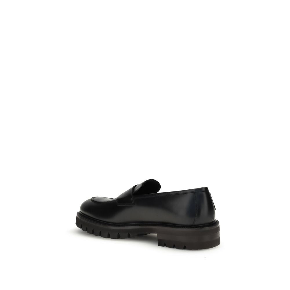 Rear view of Ferragamo Black Rubber Slip-On Loafers showing rugged sole and sleek design.