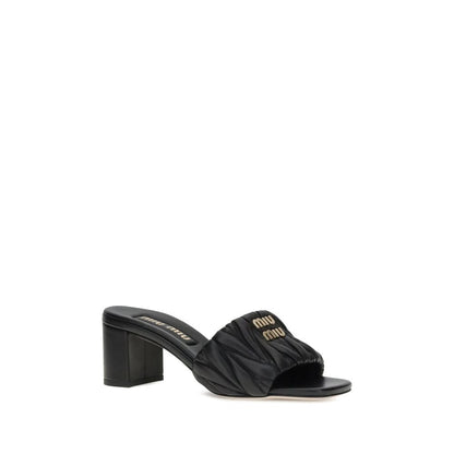 Miu Miu Black Lamb Ovis Aries Aries Stiletto Heel Sandals with padded straps and metal plaque monogram.