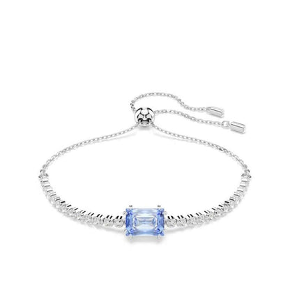 Elegant silver bracelet with blue gemstone centerpiece, SWAROVSKI brand design, adjustable chain clasp, sparkling accents.