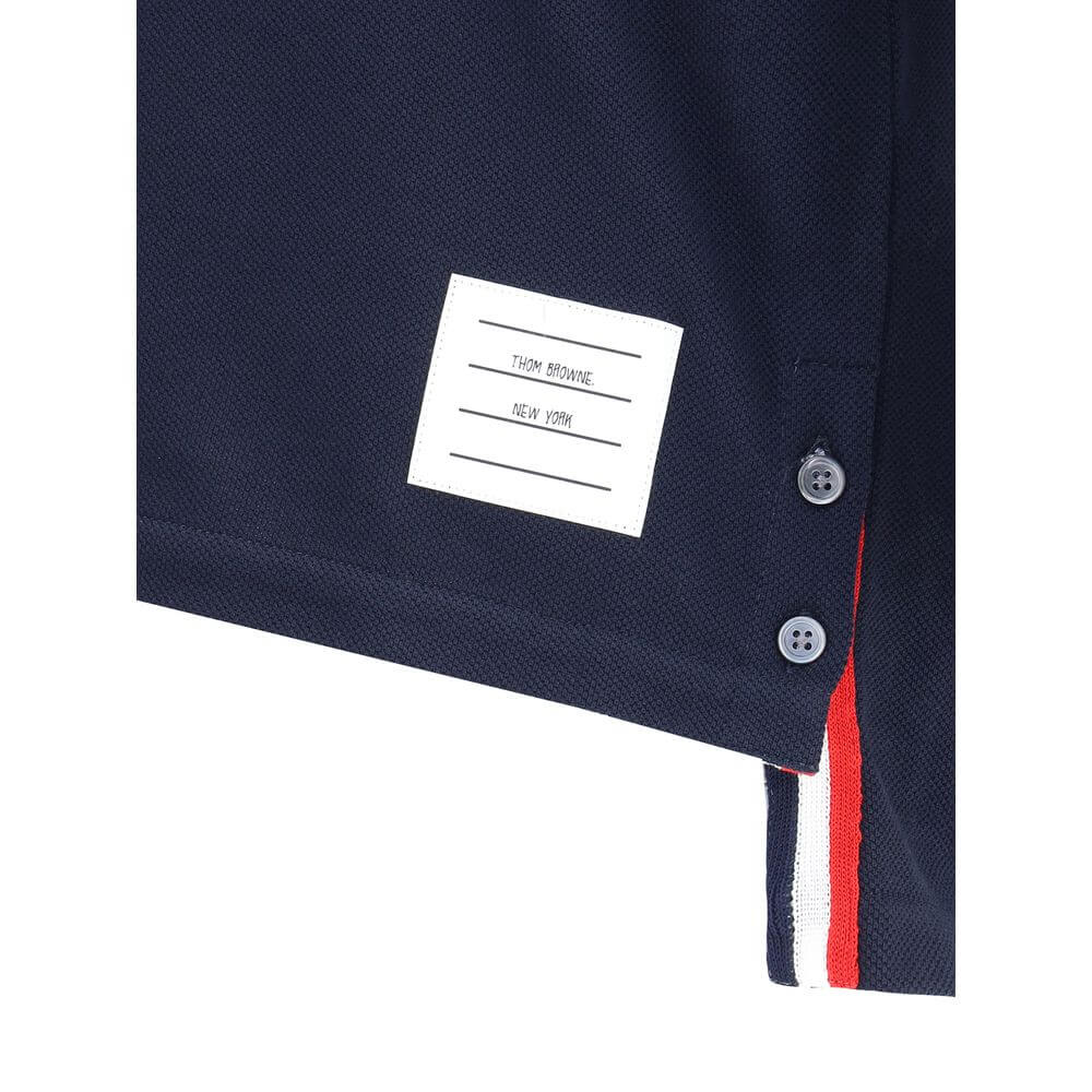 Close-up of Thom Browne Blue Cotton T-Shirt with logo patch, buttons, and iconic colored bands.
