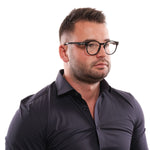 Man wearing Tod's Black Men Optical Frames with black plastic full-rim design, showcasing elegant eyewear style.